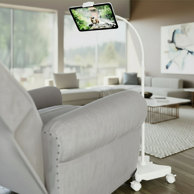 Load image into Gallery viewer, A black gooseneck tablet floor stand with casters, positioned next to a chair, displaying a tablet screen.